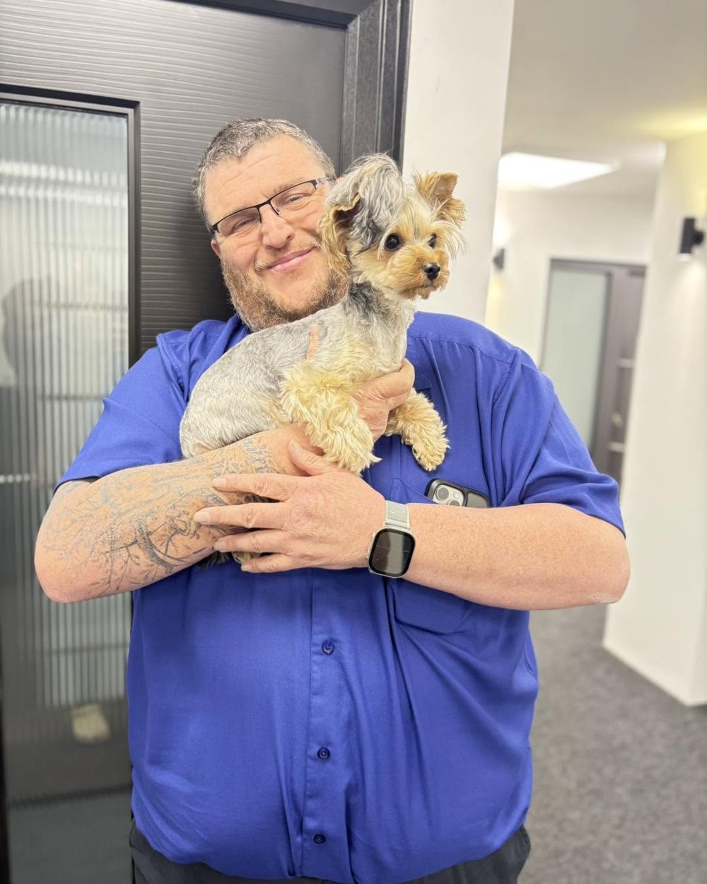 The owner of JB Doors holding his dog